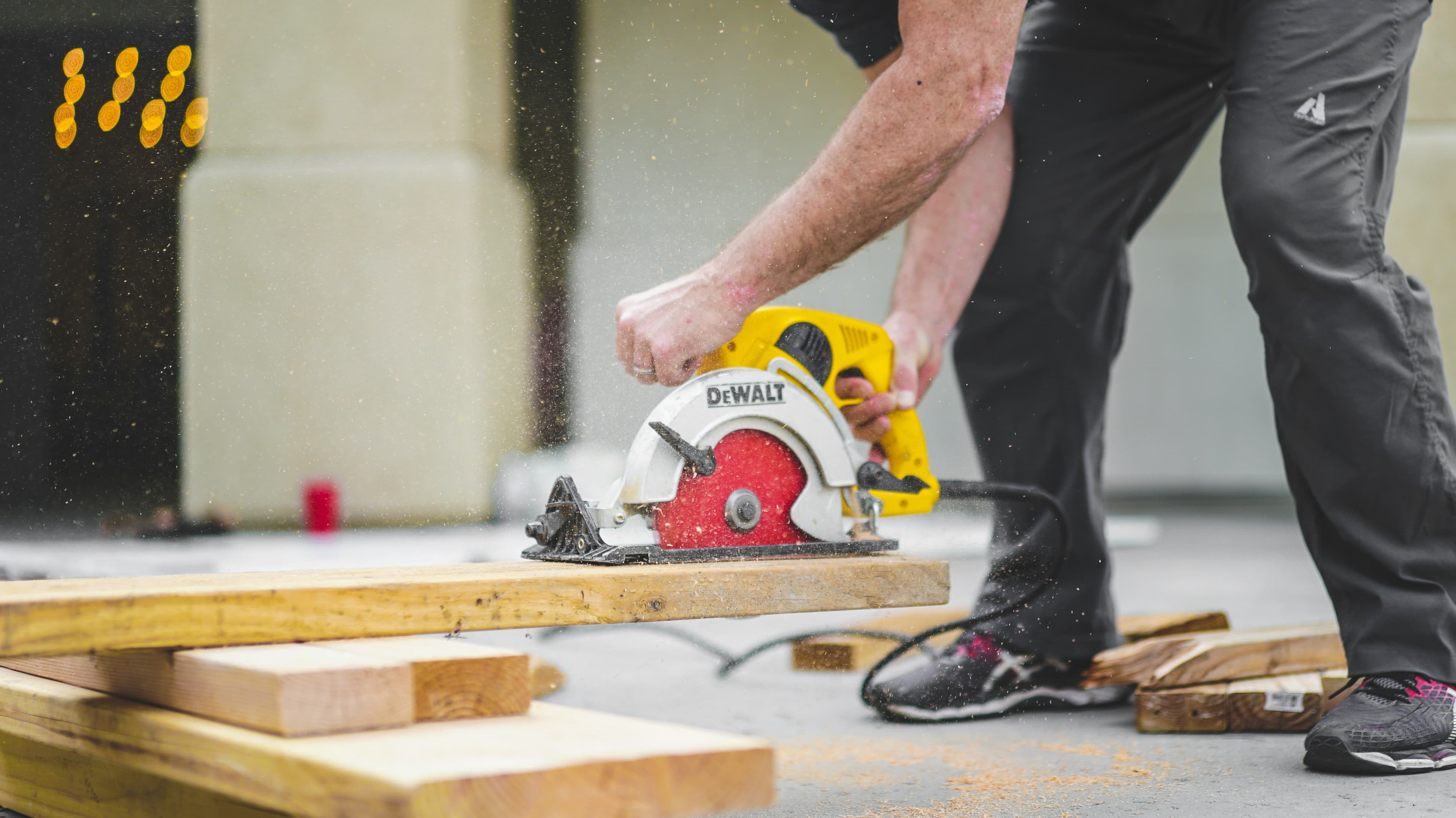 Carpenter cutting wood boards for a custom outdoor structure